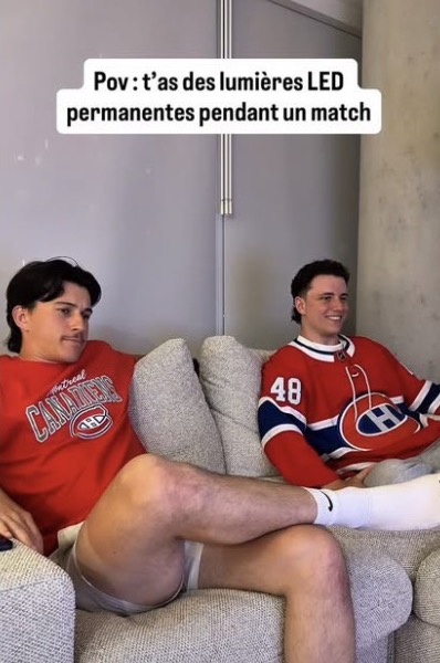 Deux amis en chandail des Canadiens regardent un match, maison éclairée aux couleurs de l’équipe